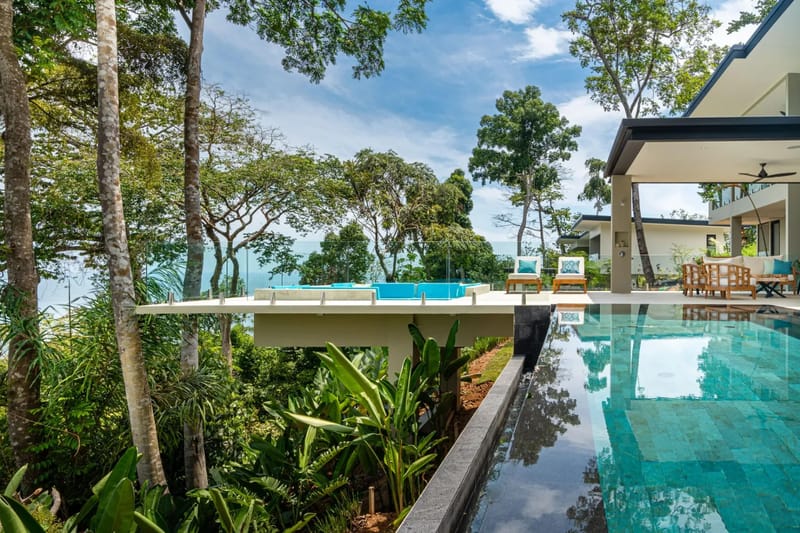 Casa La Vista · 12. An infinity pool with turquoise tiling connects to a raised sun deck with a jacuzzi, overlooking the ocean and tropical forest.