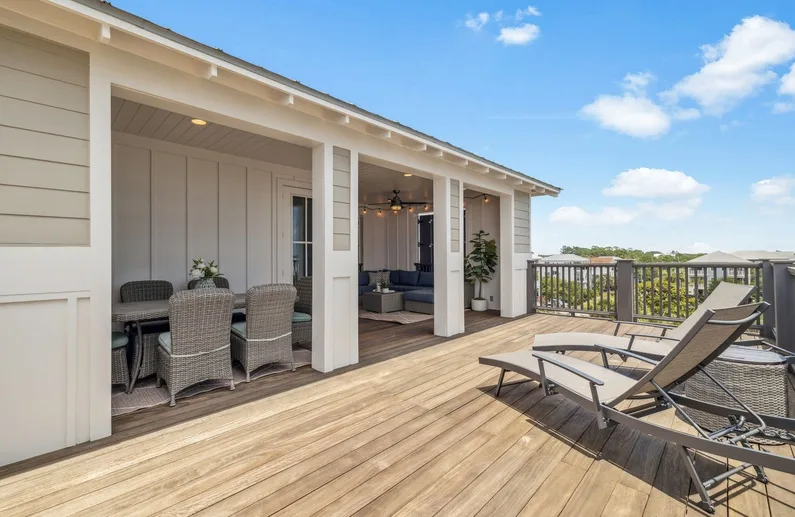 A spacious outdoor deck with lounge seating and a covered sitting area.