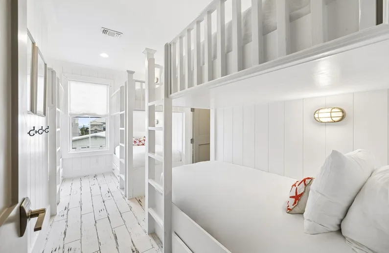 Un dormitorio luminoso con una zona elevada para dormir y una cama debajo.