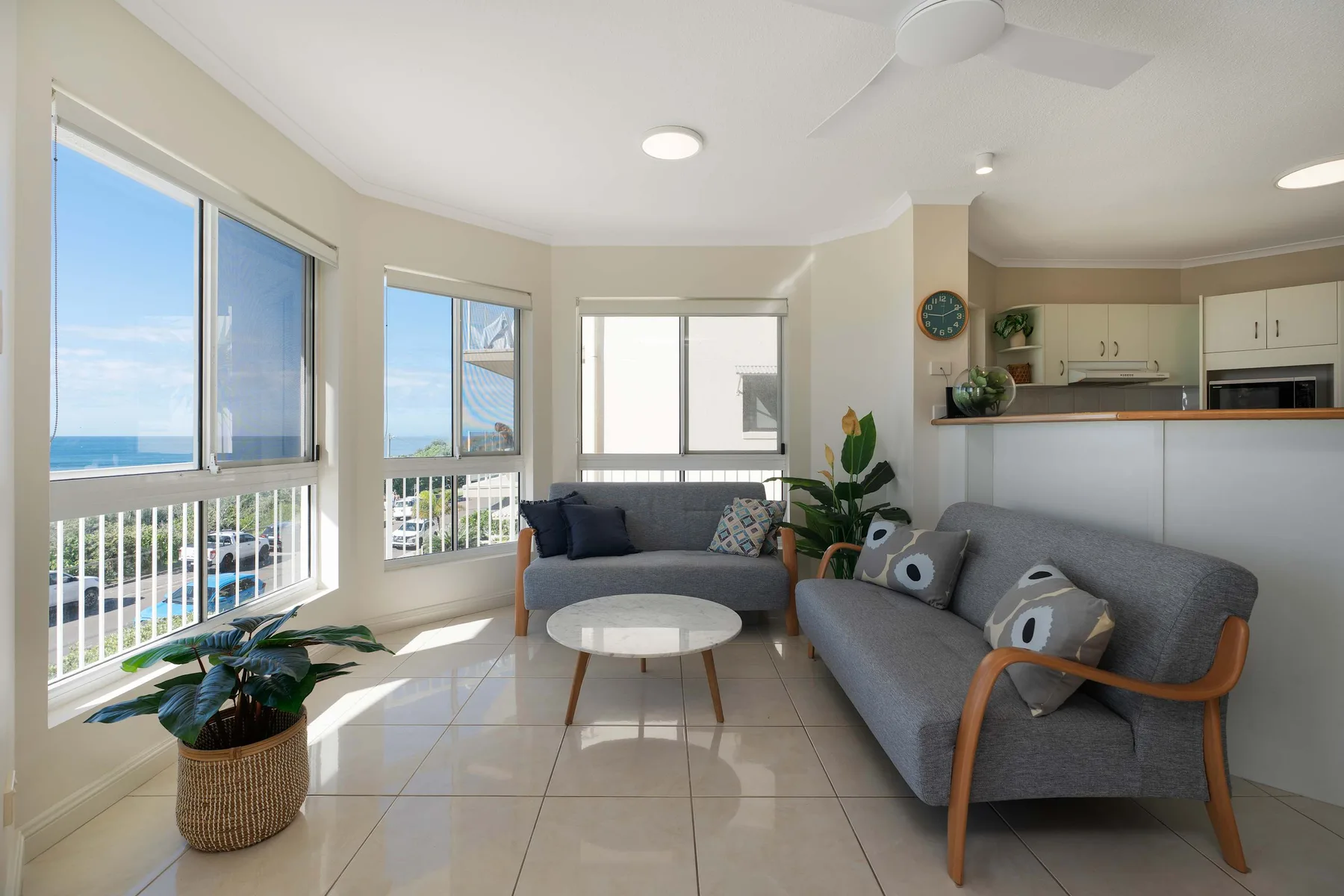 Una sala luminosa con asientos junto a grandes ventanas con vistas al océano.