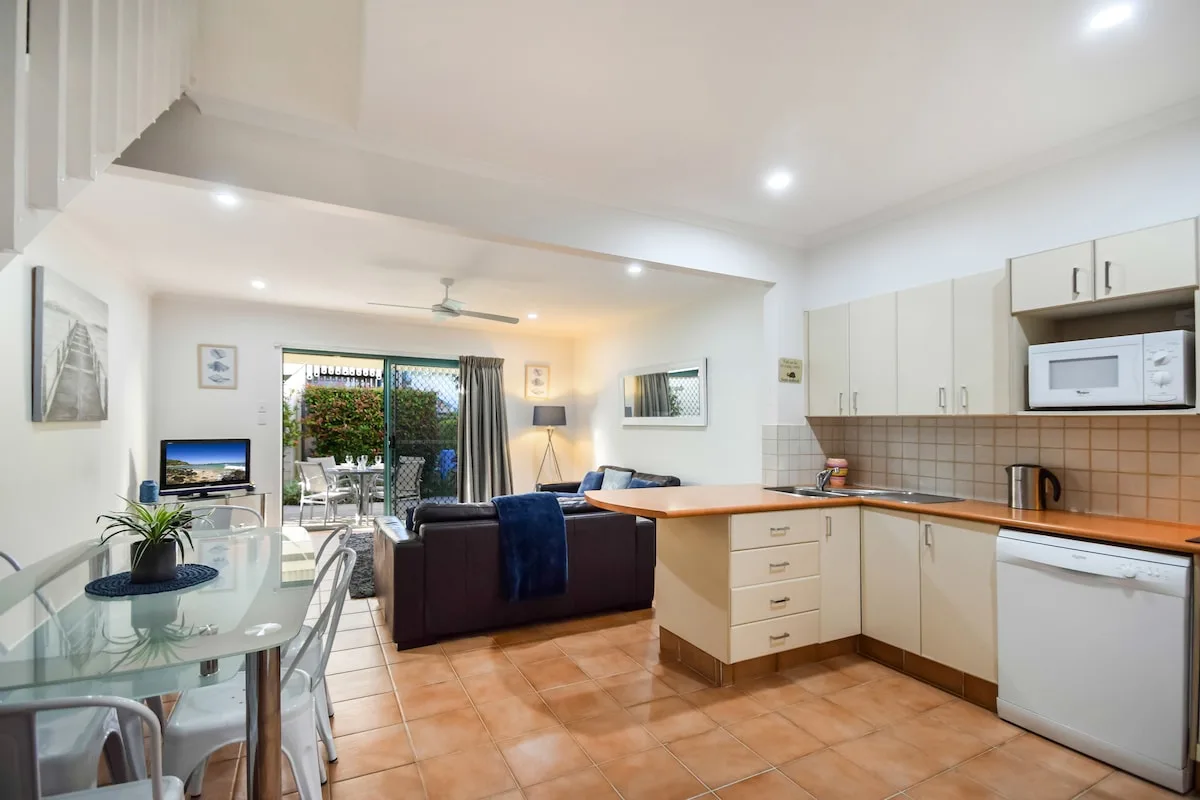 An open-plan living and dining area with a kitchen and sliding glass doors.