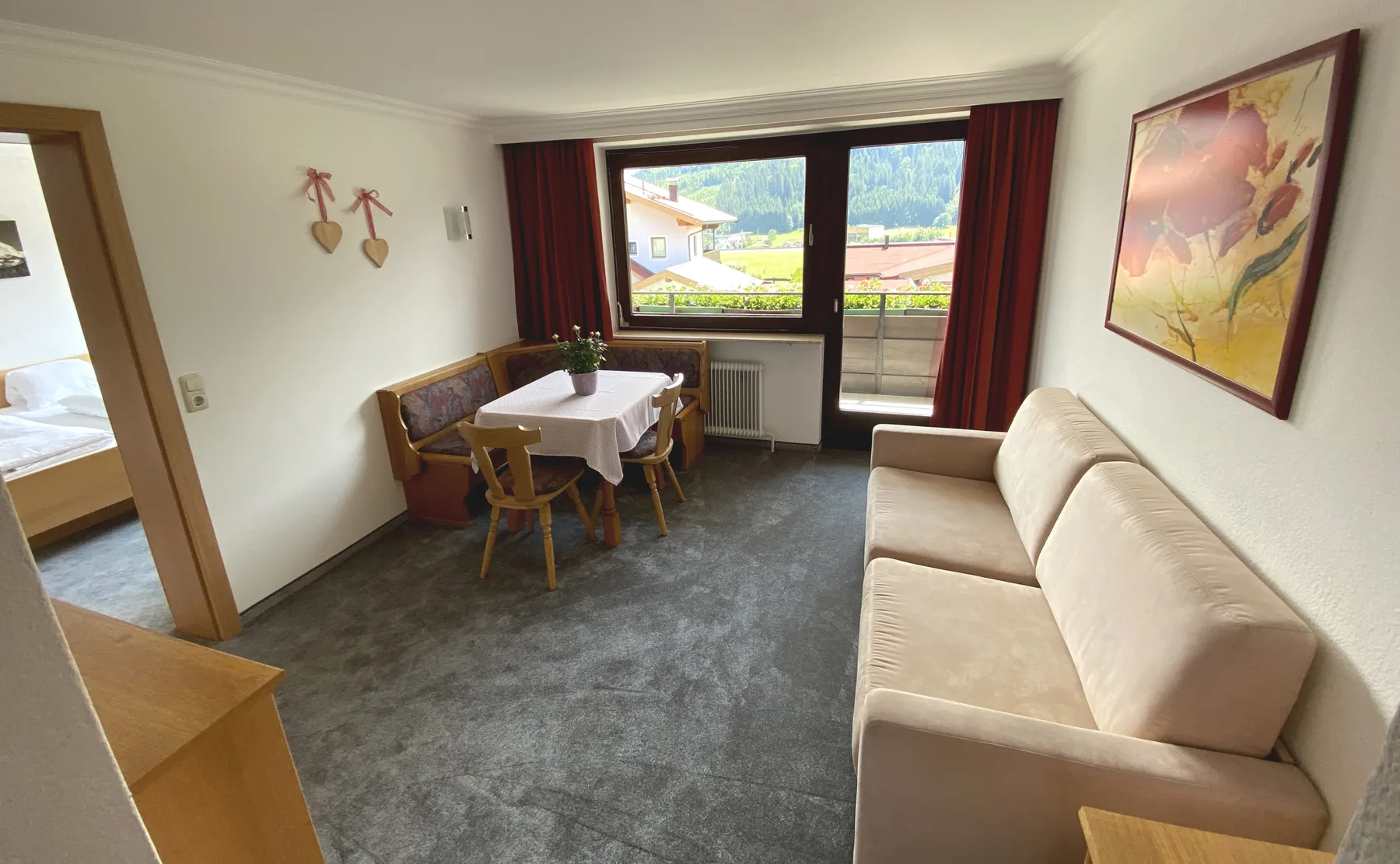 Una sala de estar con asientos y una mesa de comedor junto a una ventana grande.