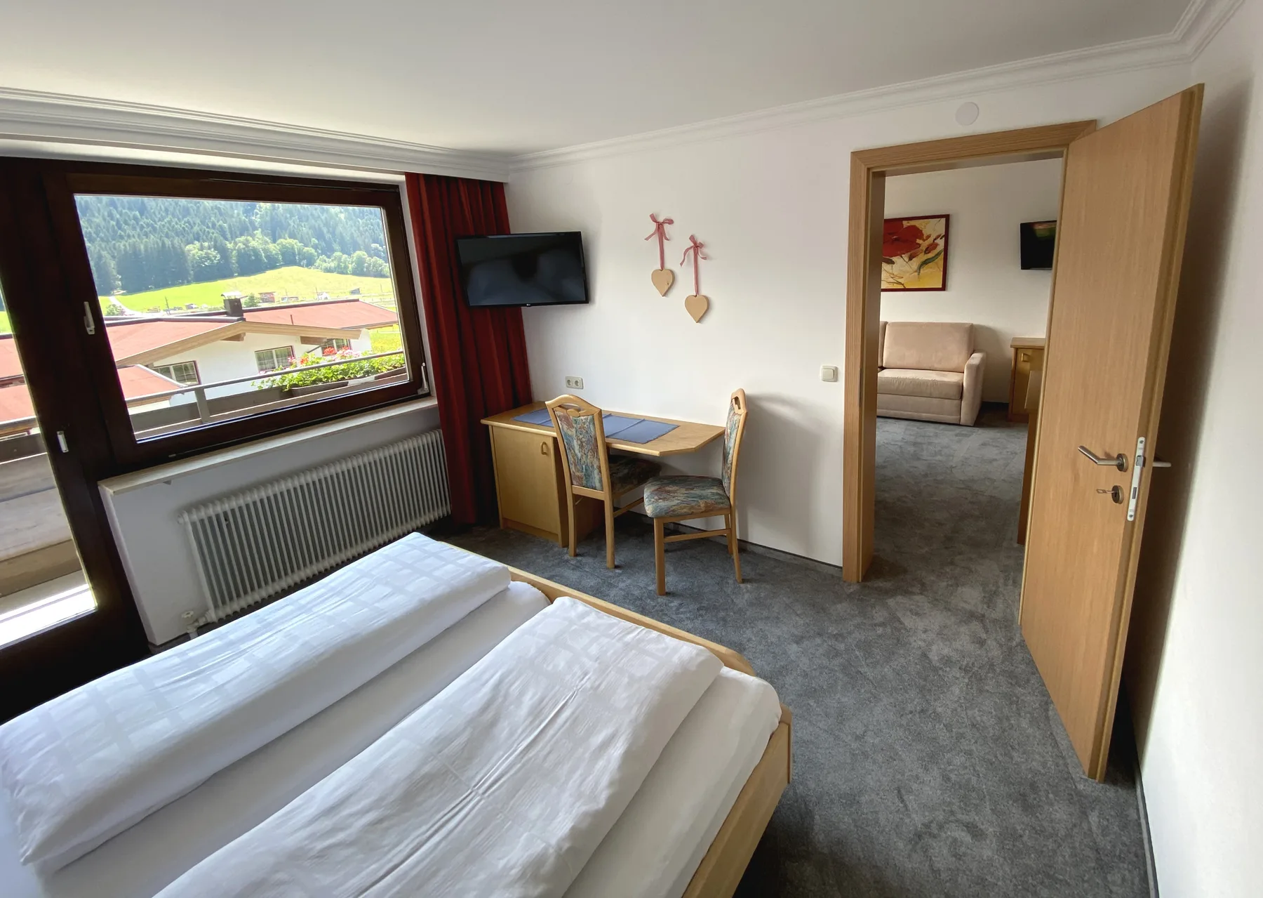 Un dormitorio con camas, un escritorio y una ventana con vistas al exterior.