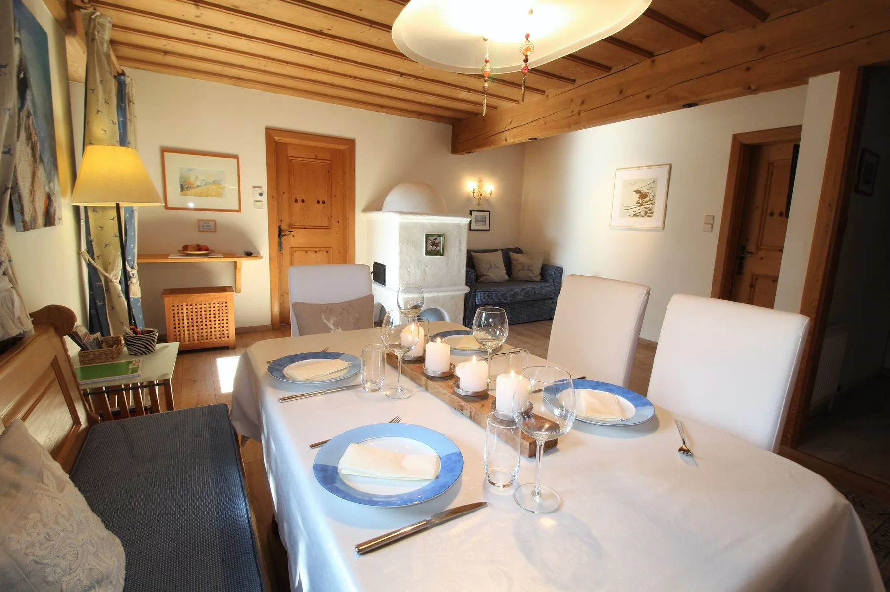 A dining area with a set table and a seating area in the background.