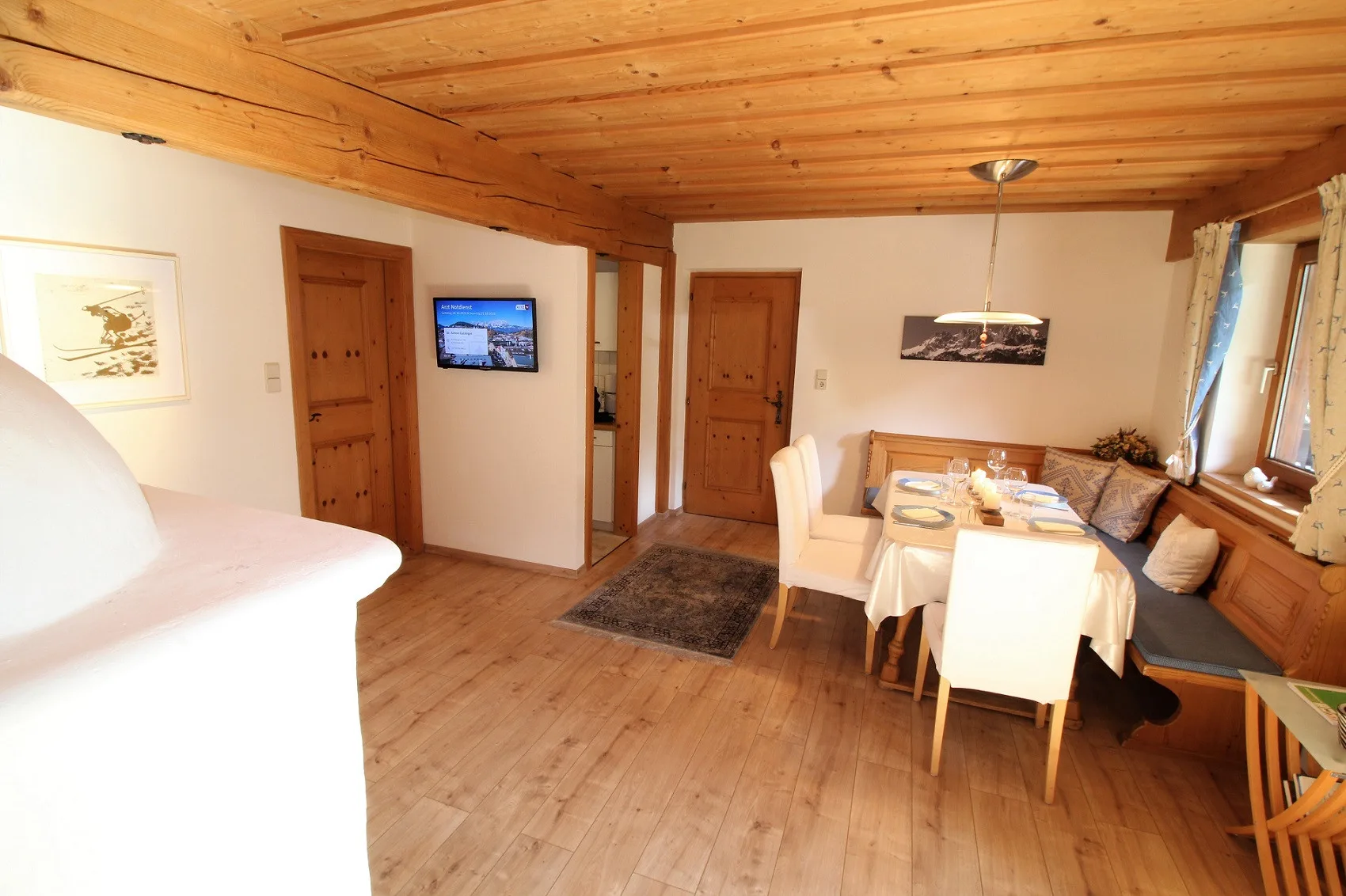 A dining area with a table and cushioned bench beside the windows.