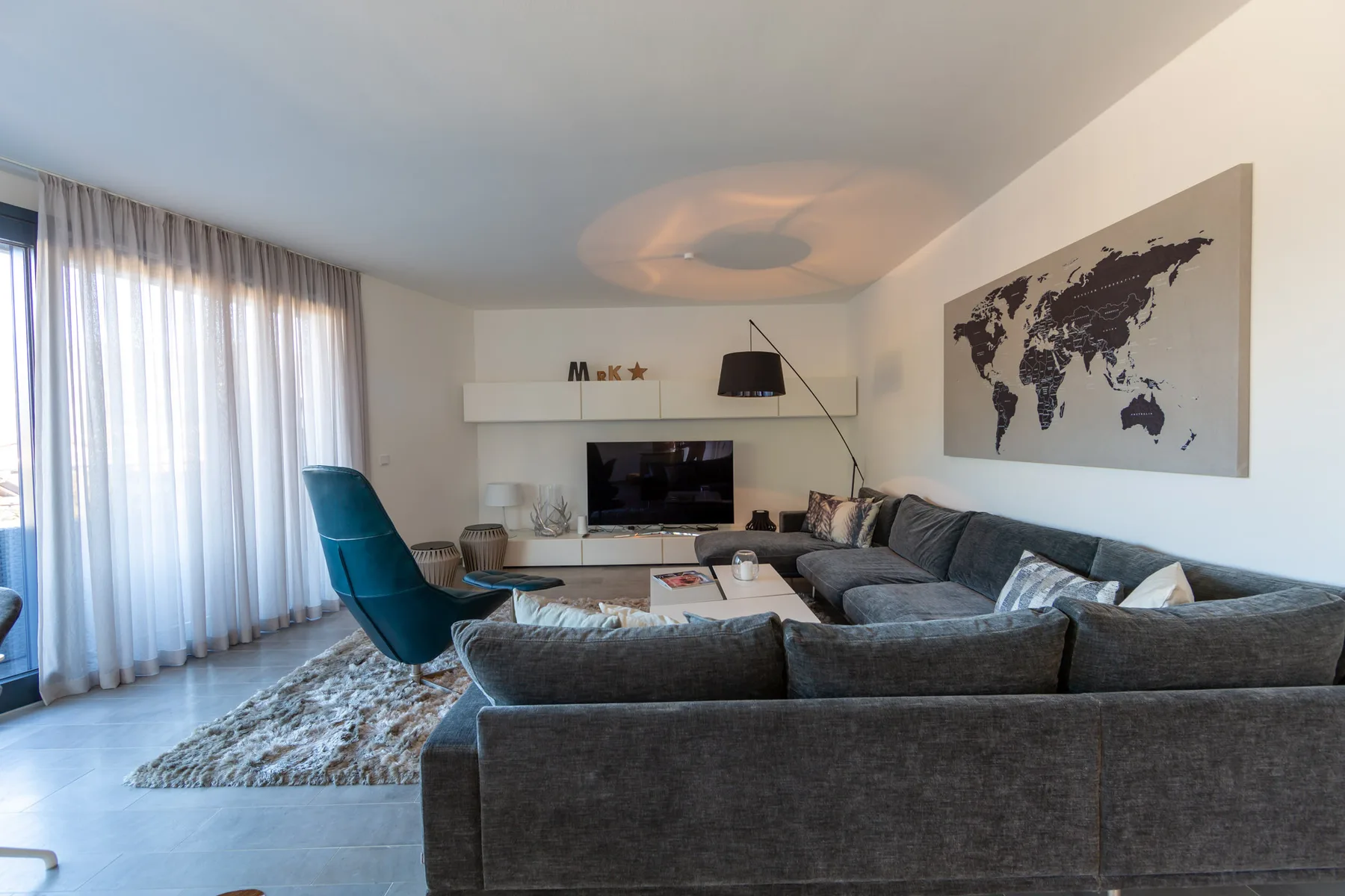 A living room with seating arranged around a low table and television.