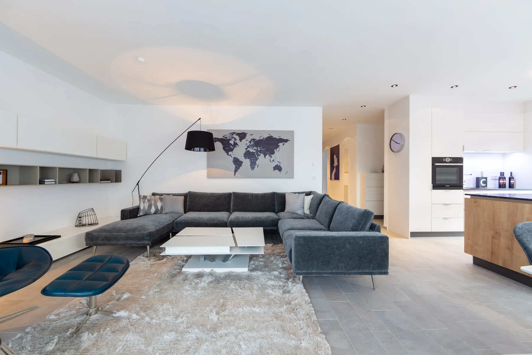 A modern living room with sectional seating, a coffee table, and a wall map.