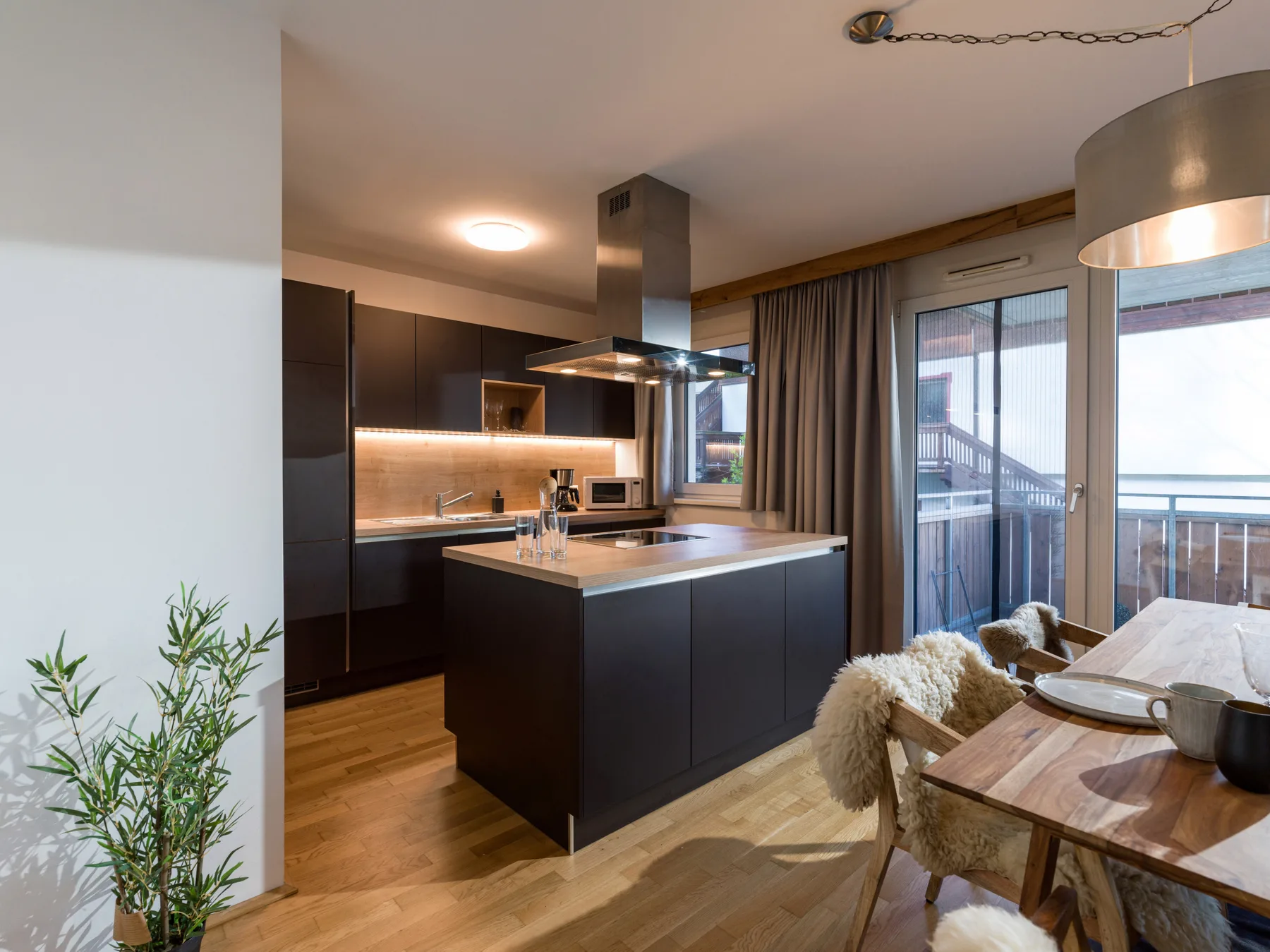 Una cocina moderna con isla central se abre a una zona de comedor.