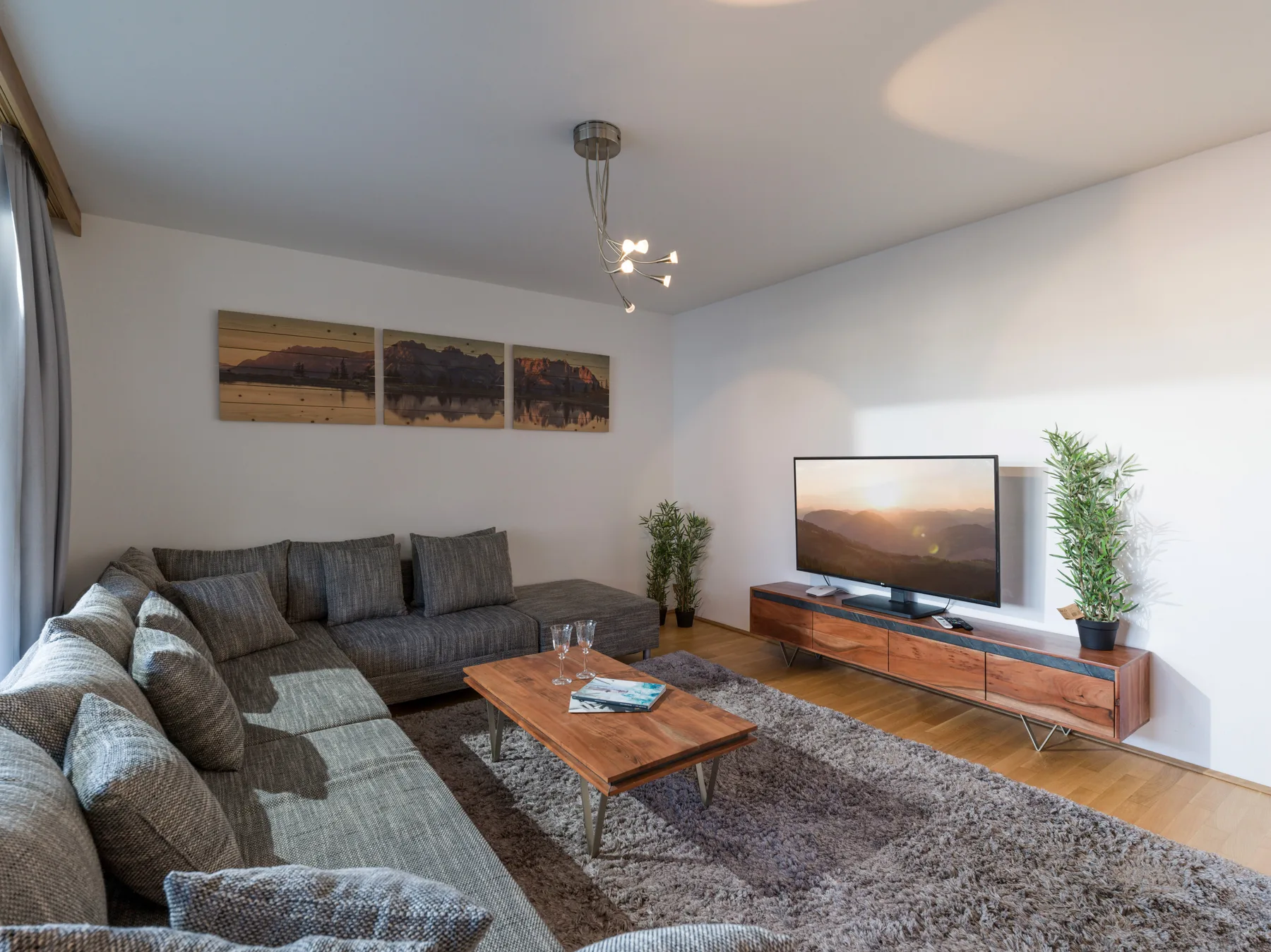 Una sala de estar con asientos, una mesa de centro y un televisor.