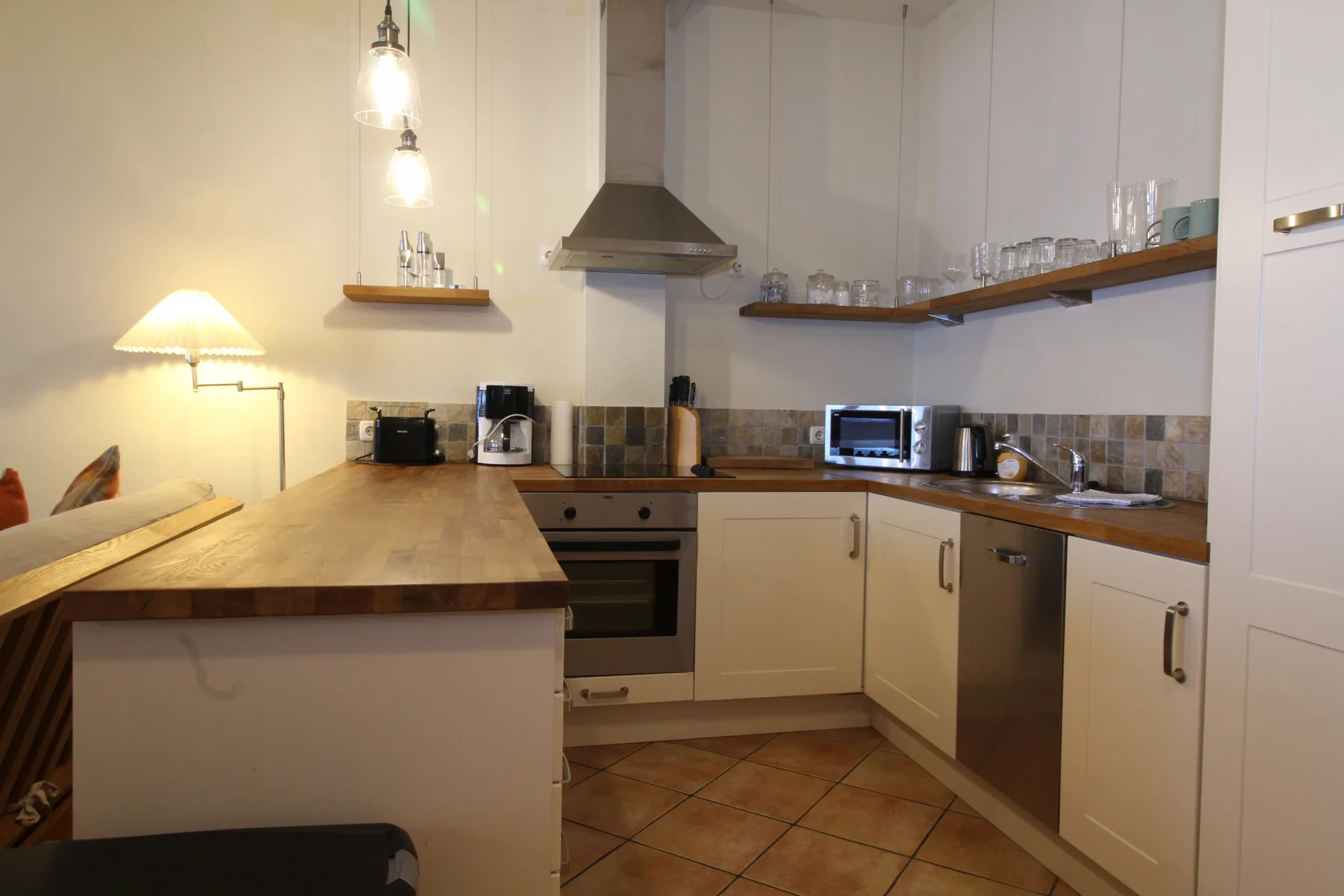 A kitchen with light-colored cabinets, wooden counters, and built-in appliances.