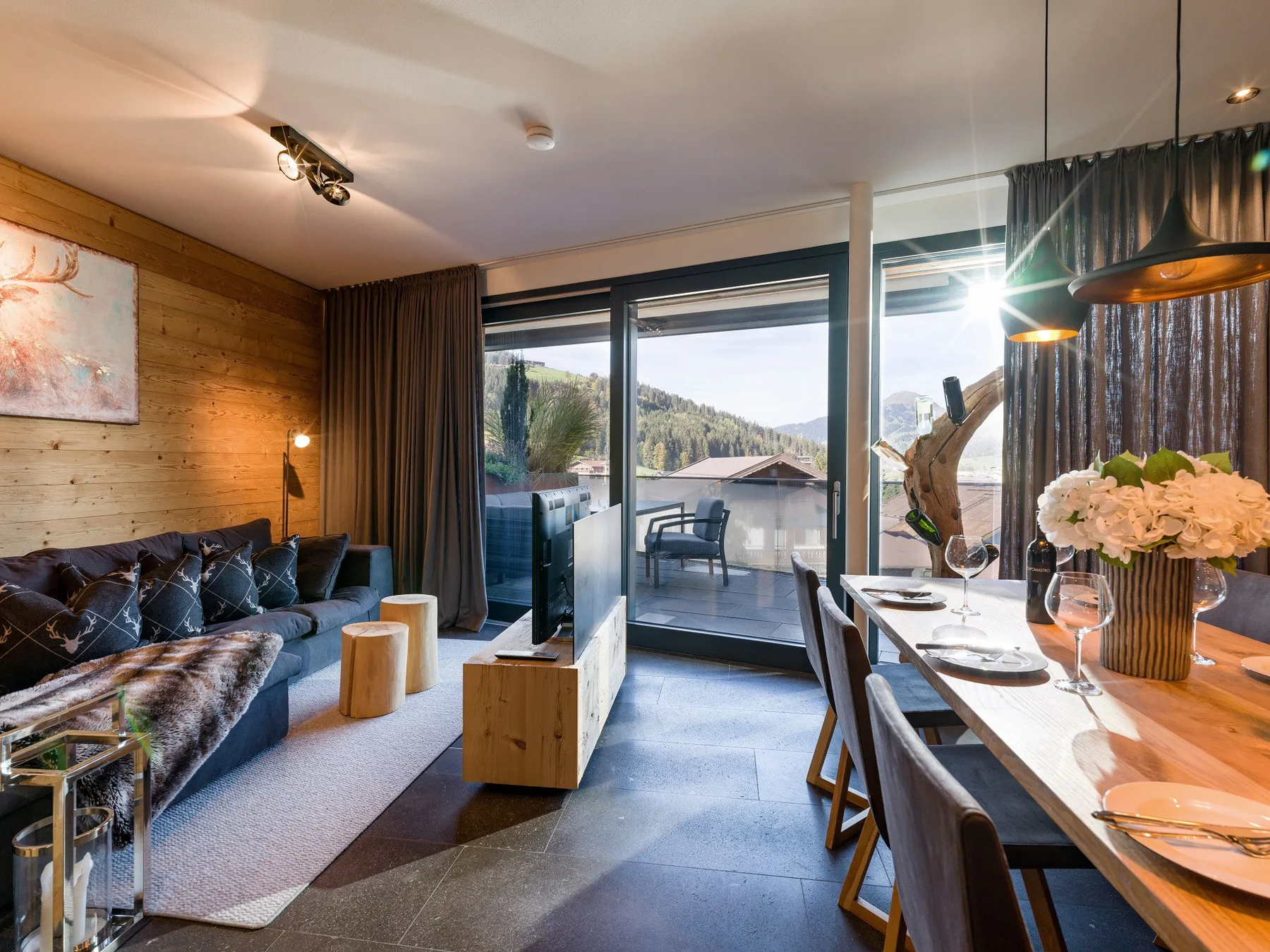 Una sala de estar y comedor se abre a un balcón con vistas a las colinas cercanas.