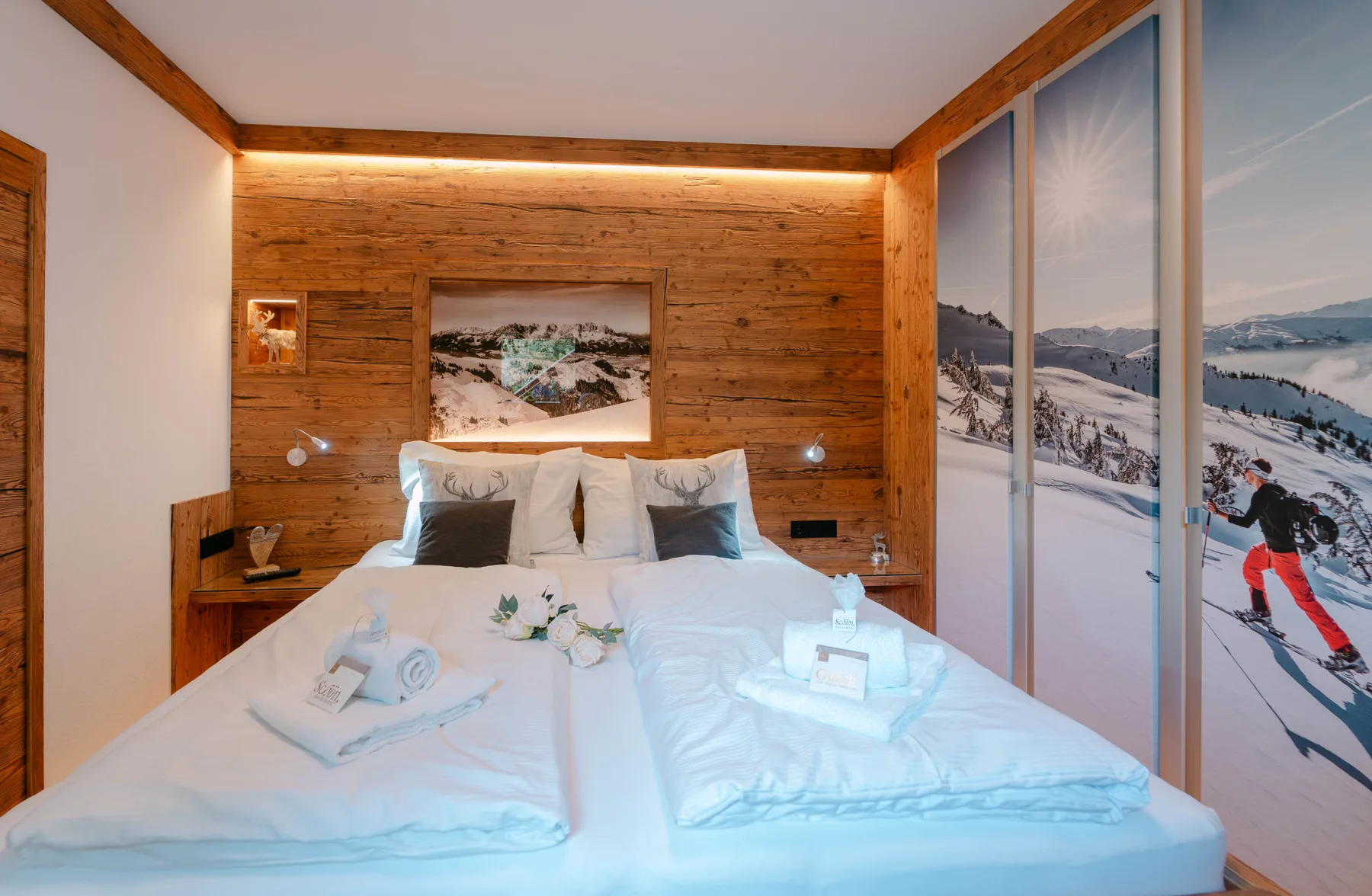 A bedroom with a white bed and wood-paneled walls.