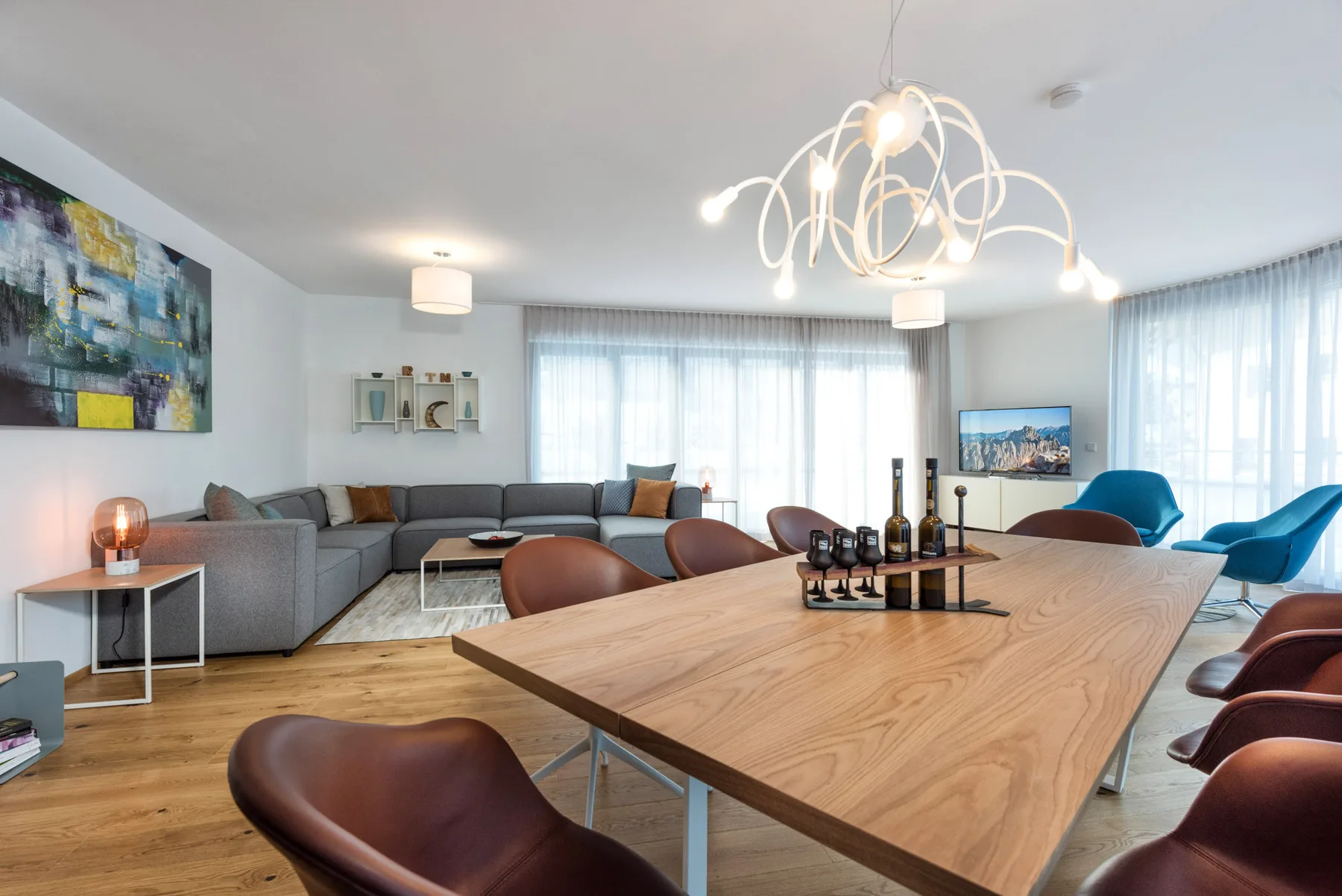 A modern living and dining area with a large wooden table and seating.