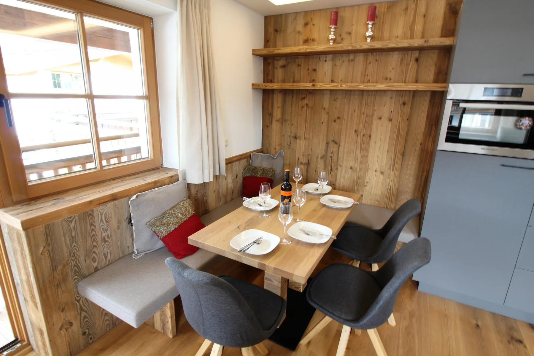 Un rincón de comedor con una mesa de madera junto a una ventana.