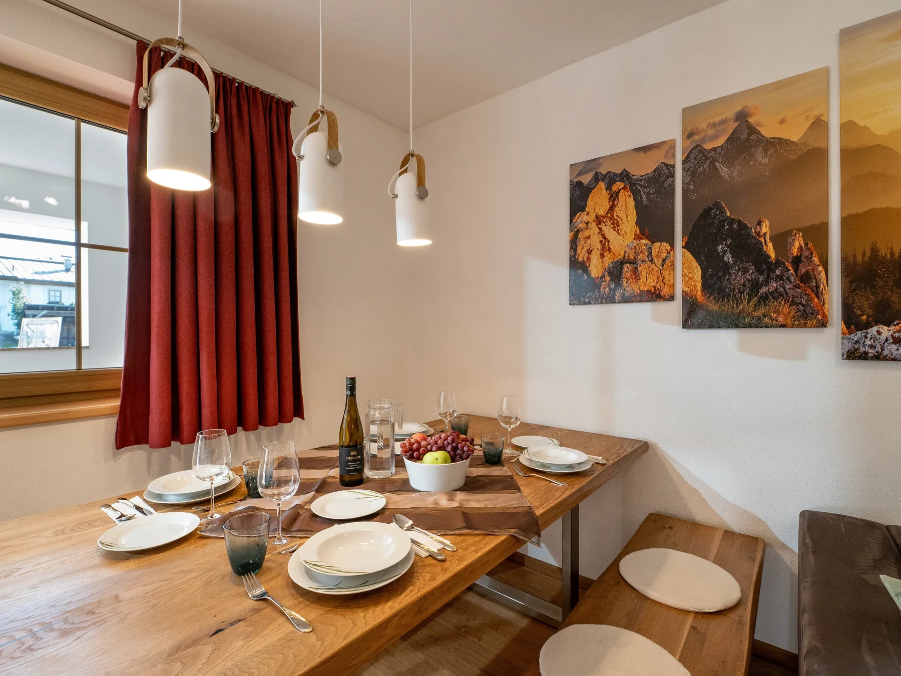 Comedor con una mesa de madera preparada para comer junto a una ventana.