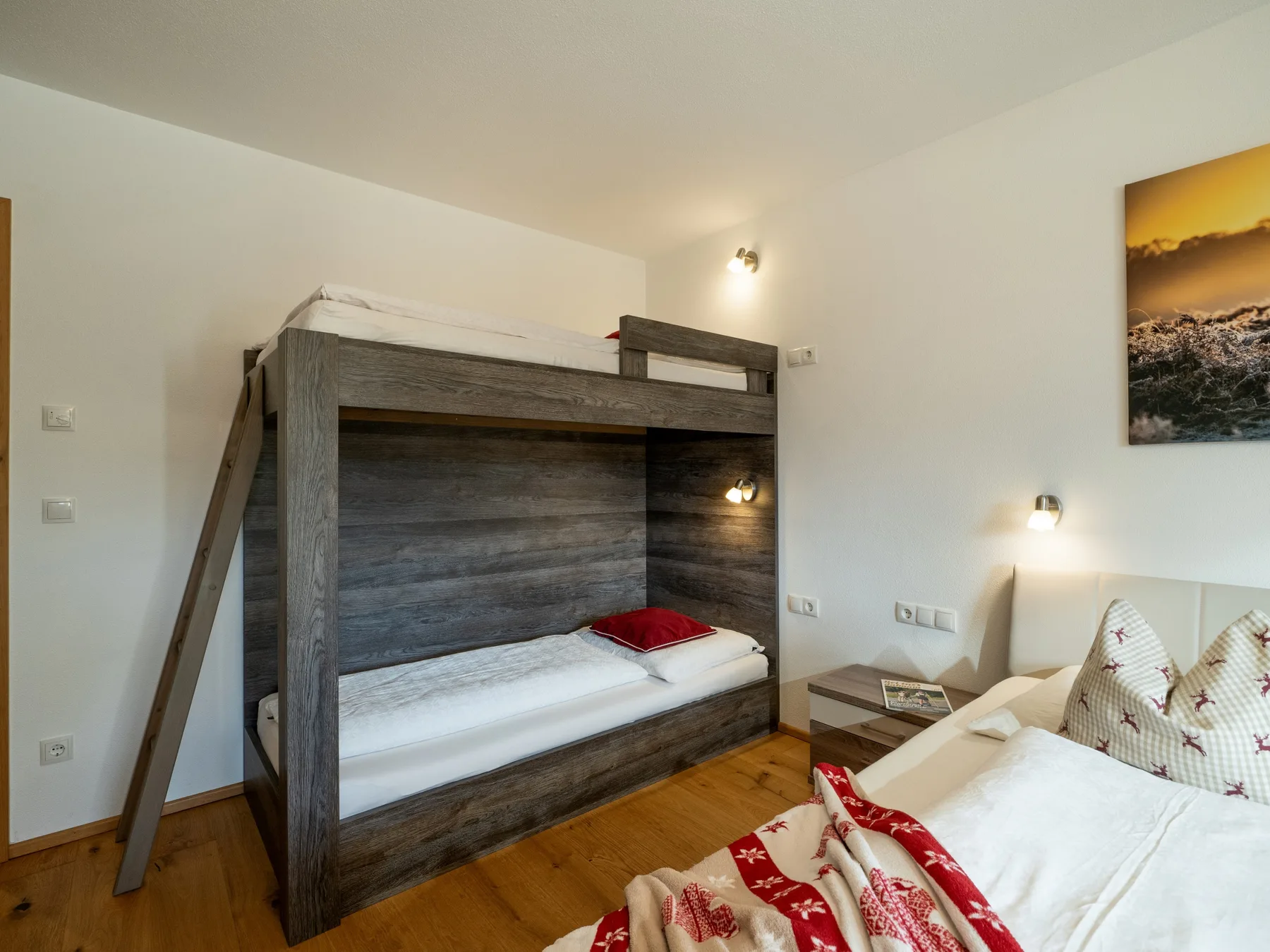 Un dormitorio con una litera de madera oscura y una cama doble.