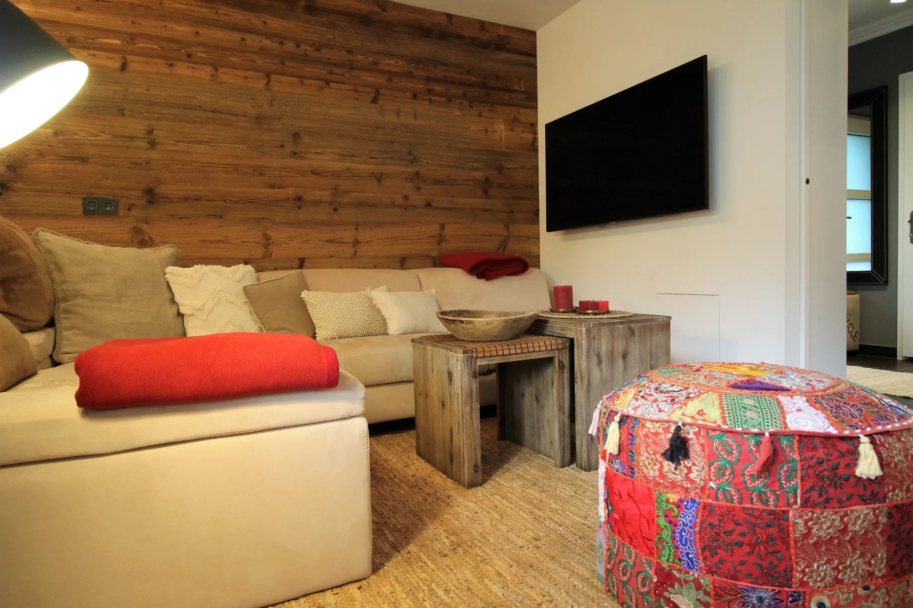 A living room with a sectional seating area, coffee table, and wall-mounted television.