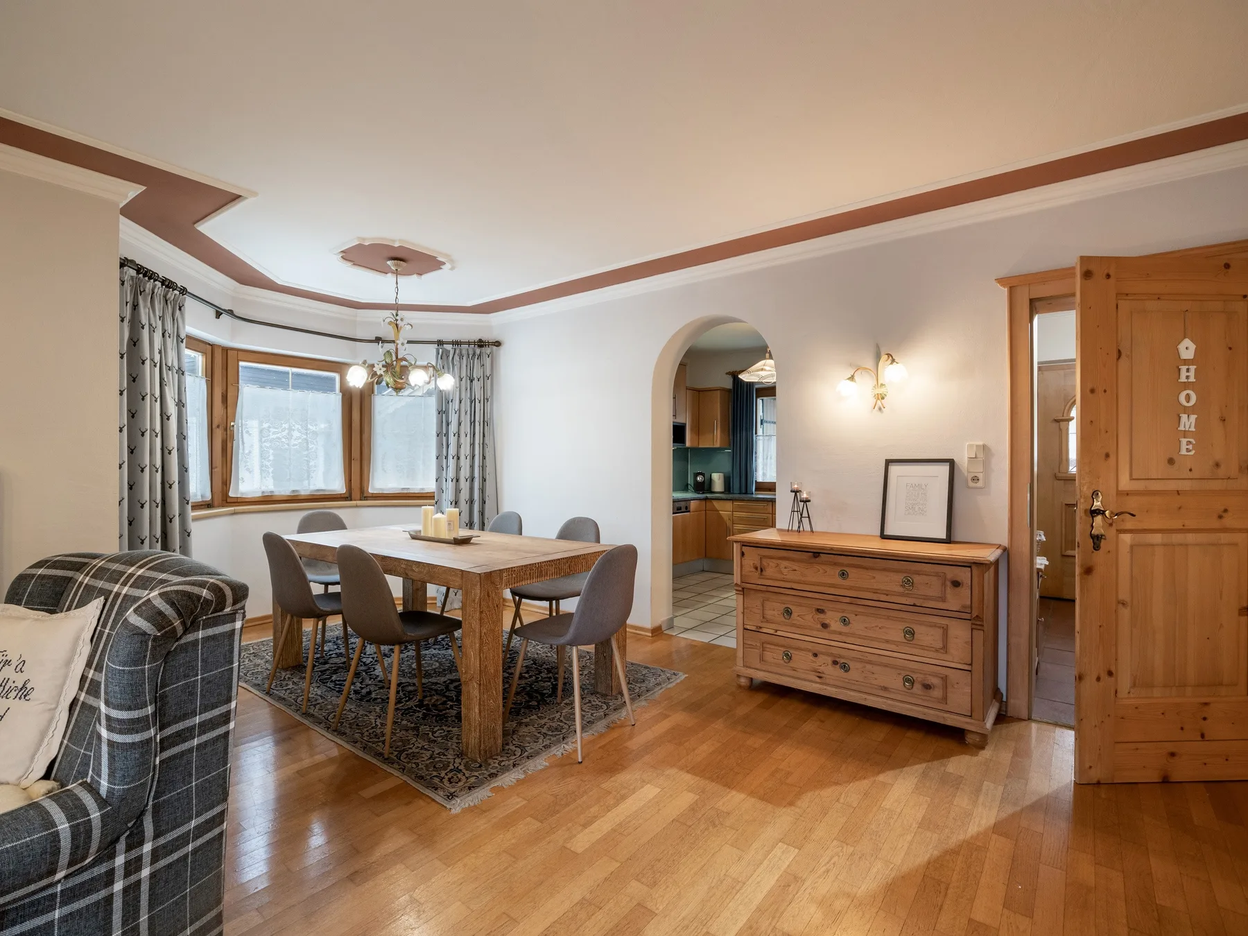 Un comedor con una mesa de madera y asientos junto a una cómoda.