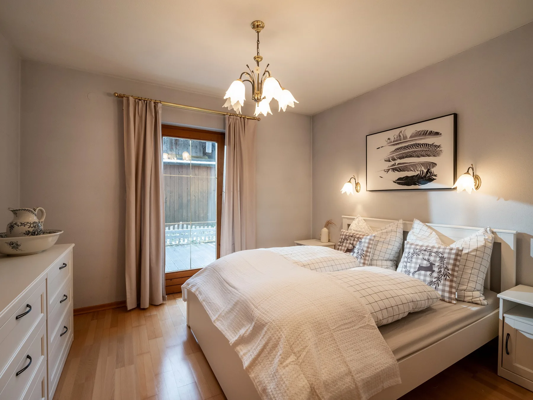 Un dormitorio con cama doble, lámparas de mesita y una ventana con cortinas.