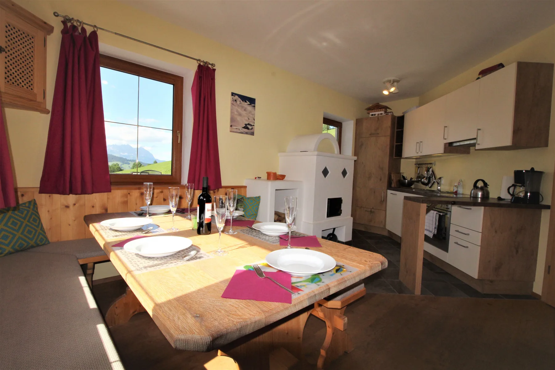 A dining area with a wooden table beside a compact kitchen.