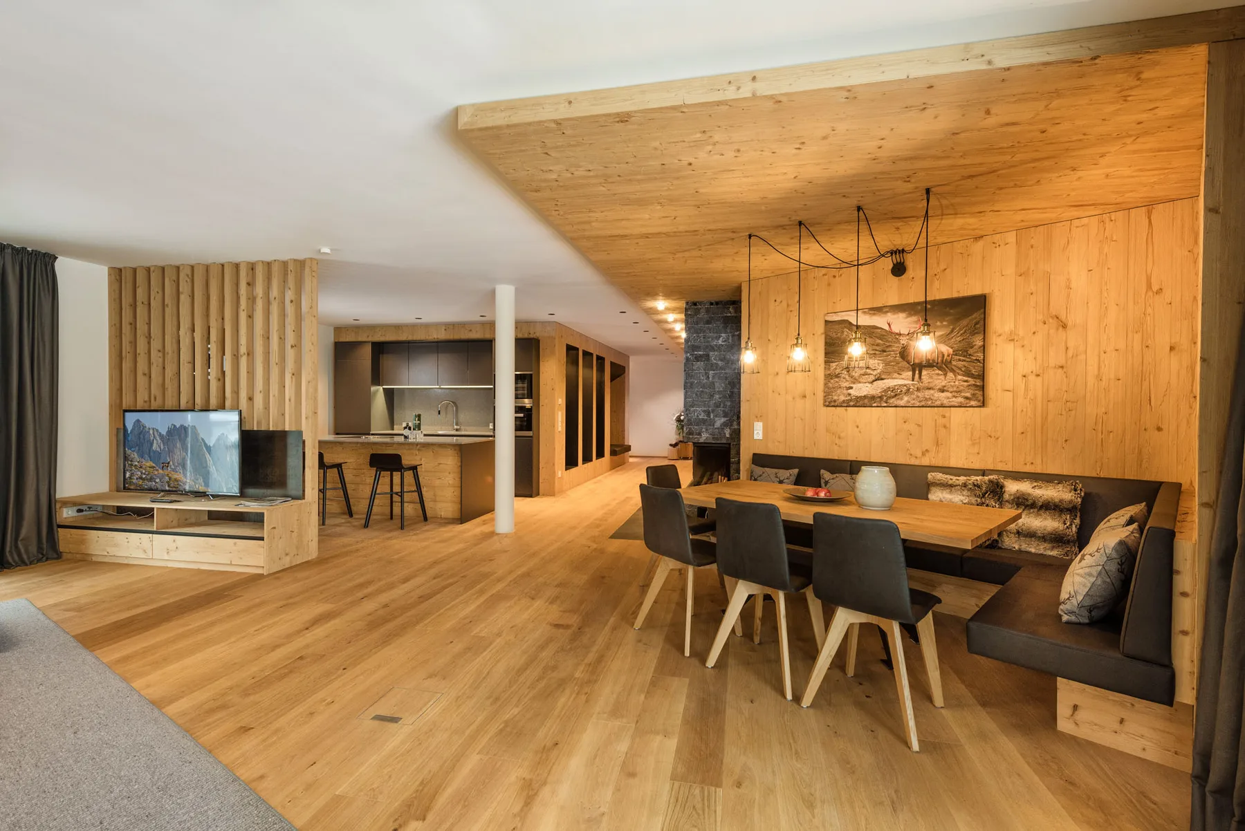 A wood-paneled living and dining area with a table, seating, and television.