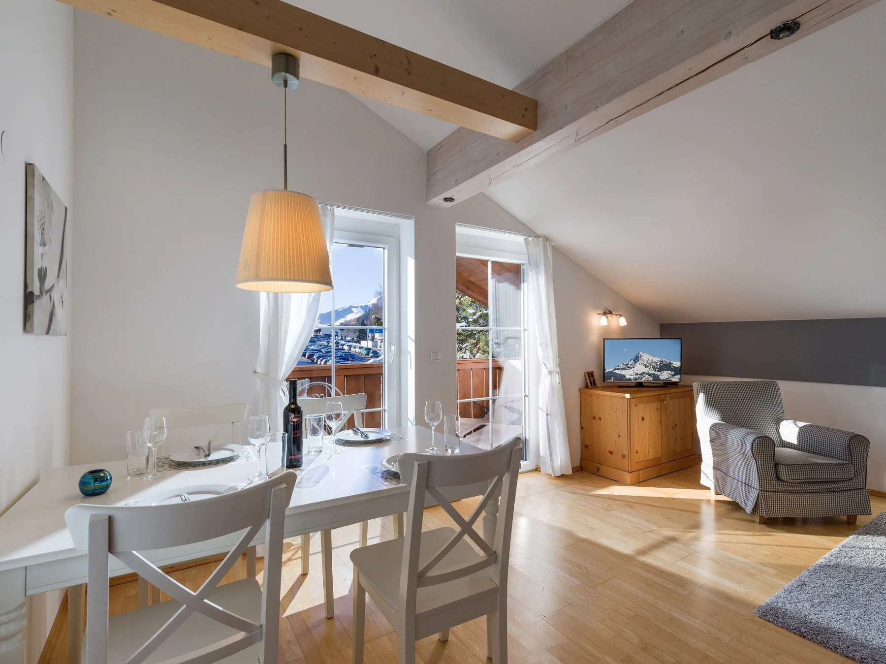 Una luminosa zona de comedor y estar tiene una mesa, asientos y ventanas con vistas al exterior.