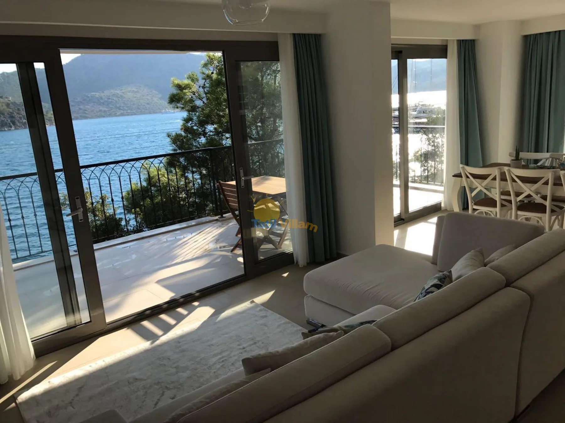 Una luminosa sala de estar y comedor se abre a un balcón con vistas al agua.