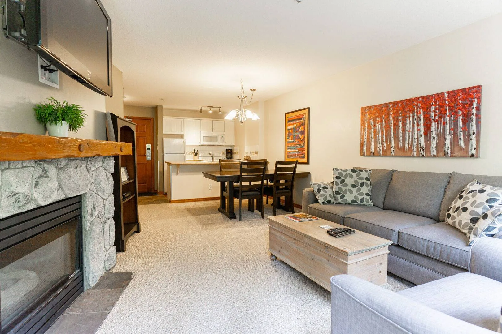 A living room with a gray sofa, coffee table, and dining area.