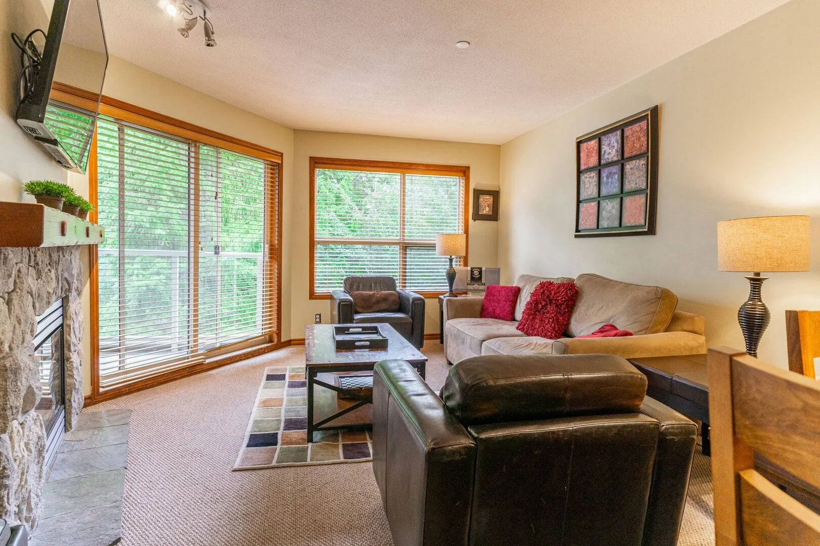 A living room with seating, a coffee table, and large windows.