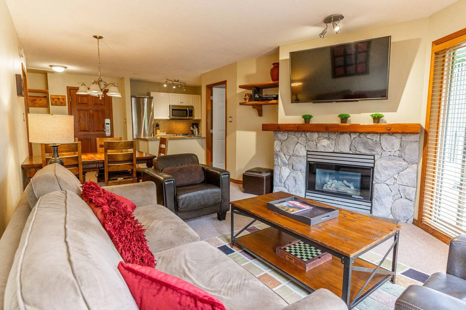 A living room with seating, a fireplace, and a television above the mantel.