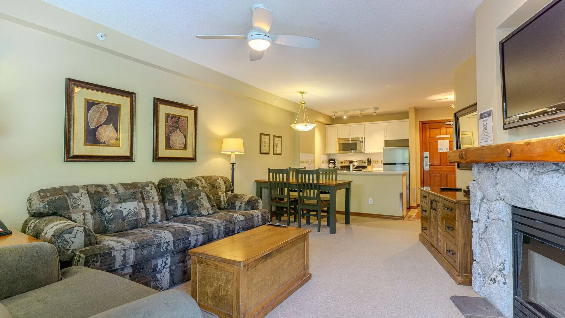 A living room with seating, a coffee table, and a dining area.