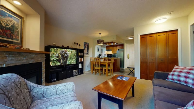 Sala de estar y cocina con televisor de 60 pulgadas