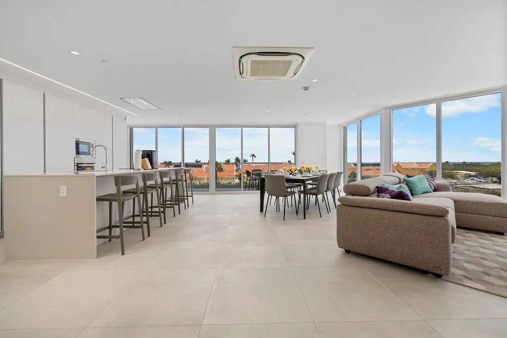 Sala de estar y comedor de concepto abierto con ventanas de piso a techo.