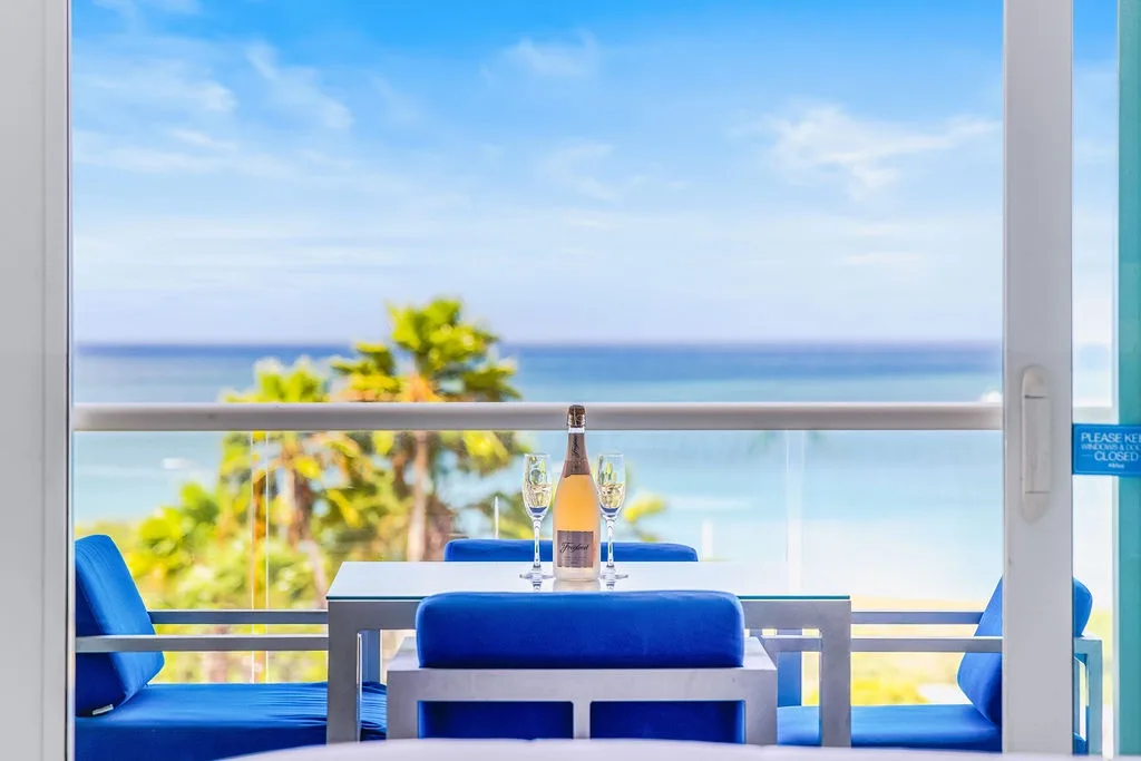 Relájate en tu balcón privado con vistas a palmeras tropicales y al mar resplandeciente; brinda por tu escapada con bebidas frías y vistas interminables al mar.