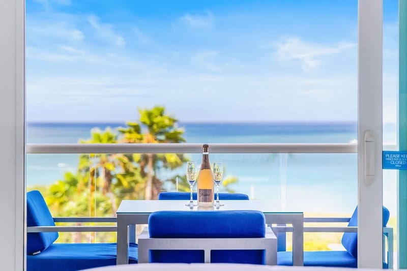 Relájate en tu balcón privado con vistas a palmeras tropicales y al mar resplandeciente; brinda por tu escapada con bebidas frías y vistas interminables al mar.