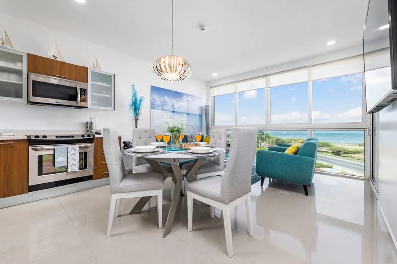 Despierta con impresionantes panorámicas del mar desde la cocina y el comedor de concepto abierto. Disfruta del café de la mañana en esta elegante mesa mientras la luz del sol entra por los amplios ventanales que revelan las aguas turquesas al otro lado.