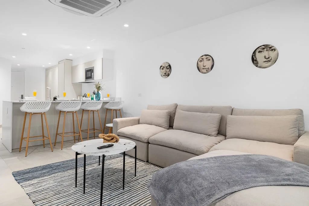 Relájese en su amplio sofá seccional mientras disfruta del diseño de concepto abierto que conecta su elegante sala de estar con una sofisticada barra de desayuno con asientos modernos.