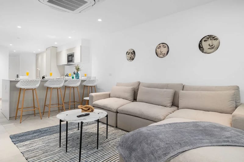 Relájese en su amplio sofá seccional mientras disfruta del diseño de concepto abierto que conecta su elegante sala de estar con una sofisticada barra de desayuno con asientos modernos.