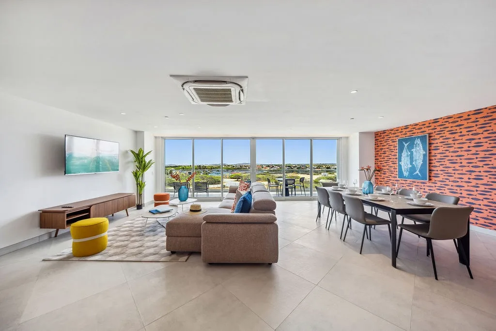 Unwind in your bright, open living space where modern design meets comfort. Floor-to-ceiling windows frame coastal views, while stylish furnishings invite relaxation and memorable gatherings.