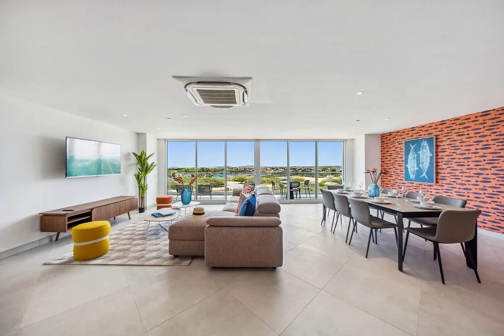 Relájese en su luminosa sala de estar de concepto abierto, donde el diseño moderno se combina con la comodidad. Las ventanas de piso a techo enmarcan las vistas de la costa, mientras que el mobiliario elegante invita al descanso y a reuniones memorables.