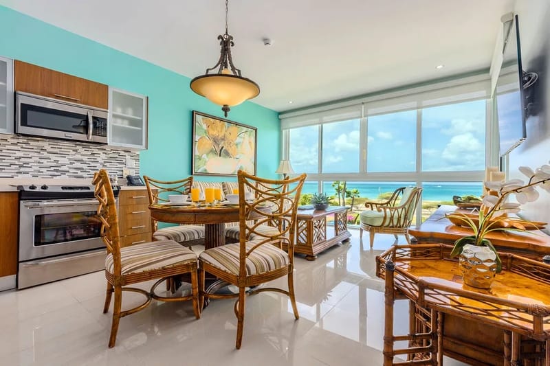 Disfrute de un café por la mañana en la mesa del comedor, con amplias vistas al mar que se extienden hasta el horizonte. La cocina abierta y la luminosa decoración costera crean un ambiente relajado y fresco, perfecto para las comidas durante las vacaciones.