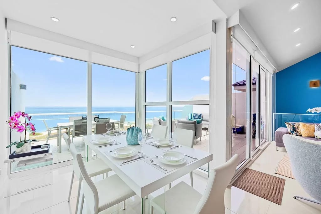 Dining space with floor-to-ceiling windows and ocean views