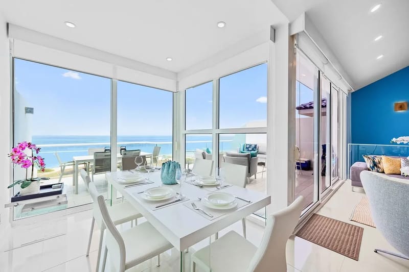Comedor con ventanas de piso a techo y vistas al mar