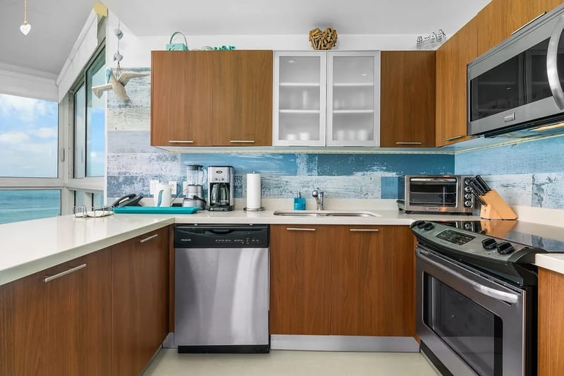 Fully equipped kitchen with ocean views through expansive windows.
