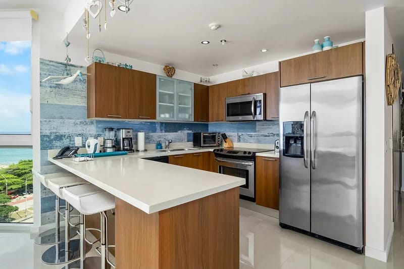 Fully equipped kitchen with modern appliances, a breakfast bar, and ocean views.