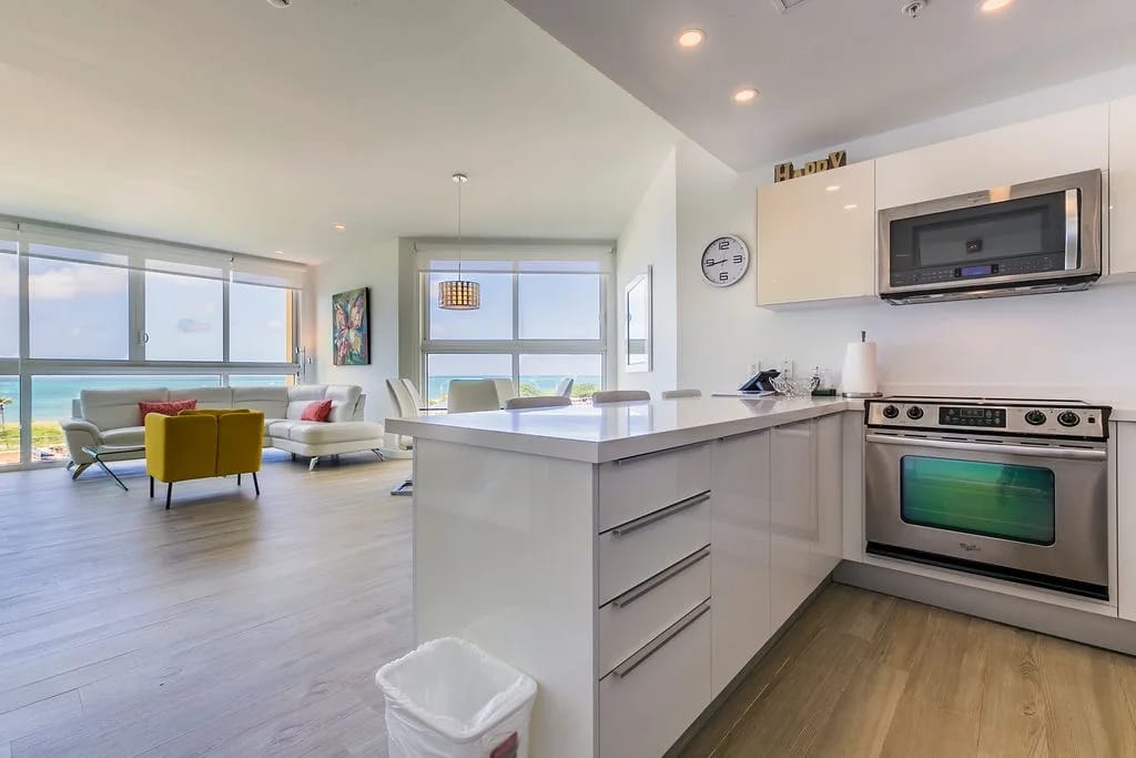 Su cocina gourmet se integra con una sala de estar bañada por el sol, donde los ventanales de piso a techo enmarcan impresionantes vistas del océano turquesa. Cocine, relájese y disfrute de la belleza costera.