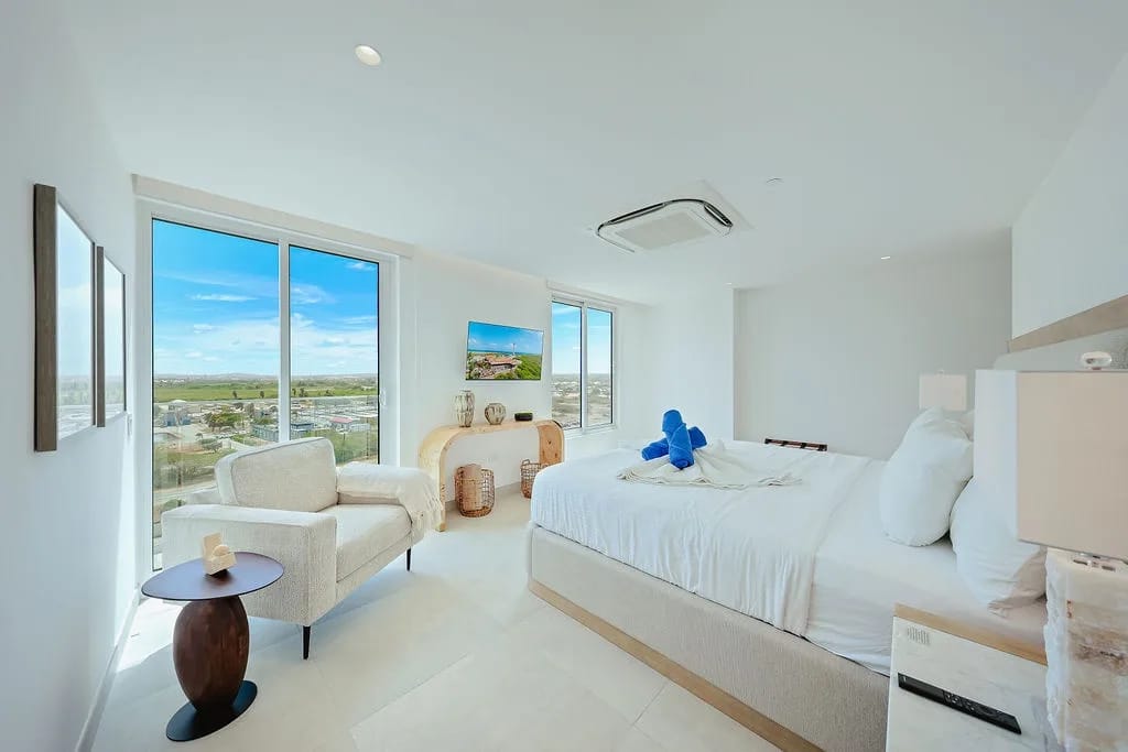Sumérgete en la suave ropa de cama y despierta con amplias vistas del campo a través de ventanas de piso a techo que inundan tu dormitorio de luz natural.