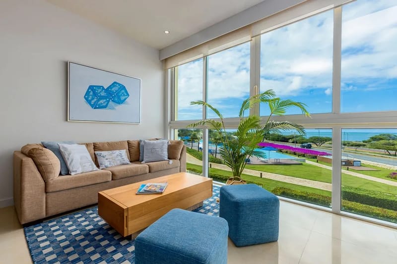 Acomódate en el mullido sofá y contempla las amplias vistas de la piscina, el exuberante césped y el mar resplandeciente al fondo: te espera una escapada serena.