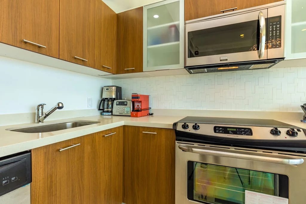 Cocina totalmente equipada con electrodomésticos de acero inoxidable y armarios de madera