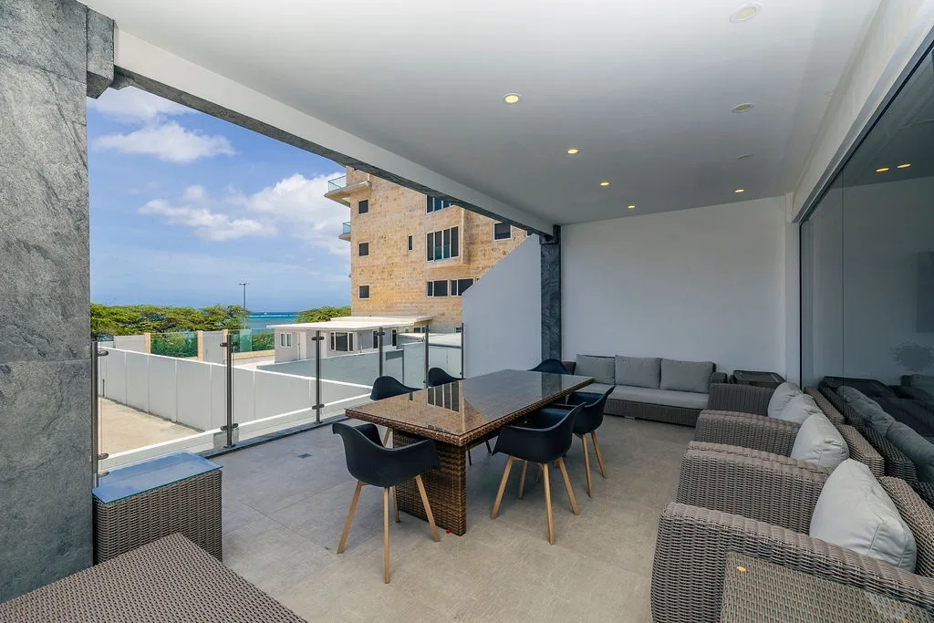 Relájese en su terraza cubierta con vistas parciales al mar, donde le esperan cómodos asientos y un espacio para comer. El lugar perfecto para descansar desde la mañana hasta la noche, combinando la comodidad interior con las brisas costeras.
